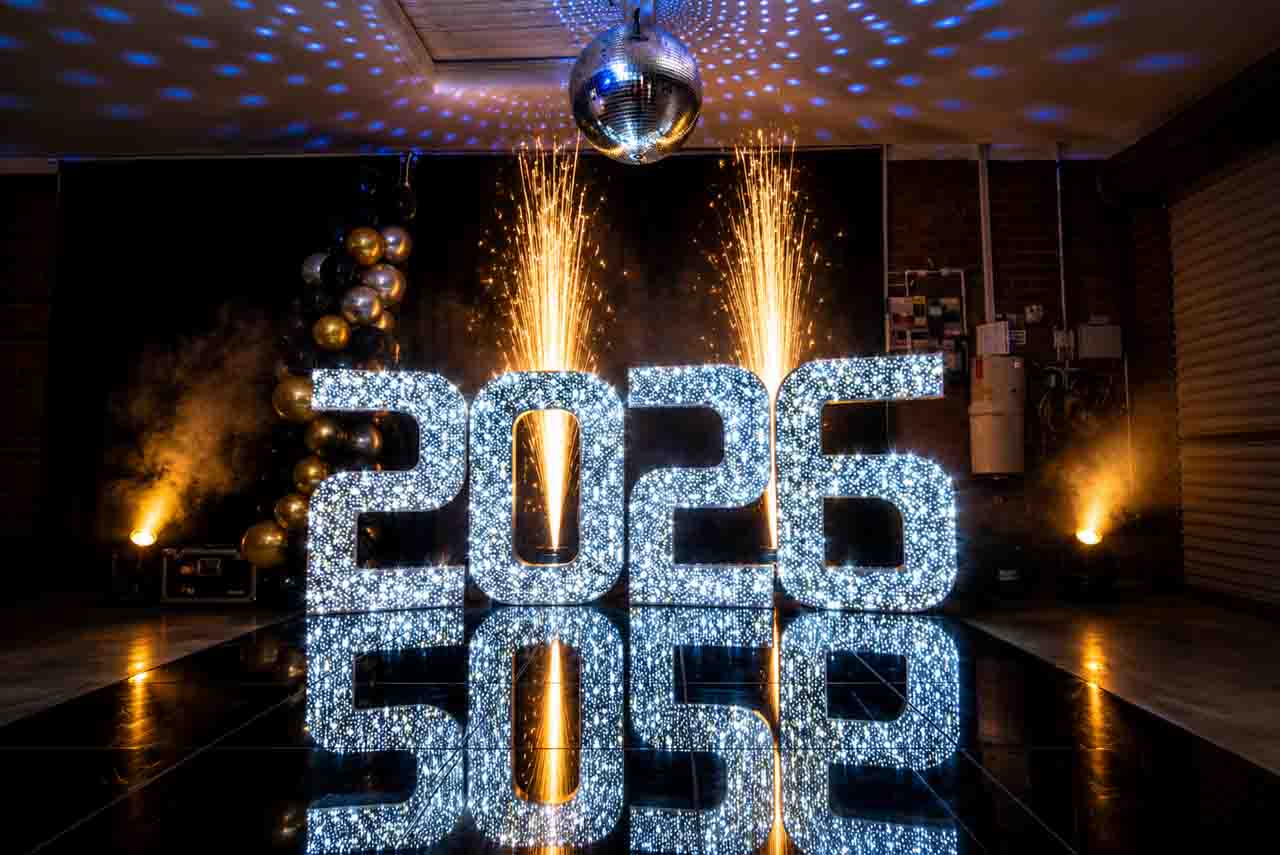 Cold sparks behind illuminated 2026 numbers and LED dance floor